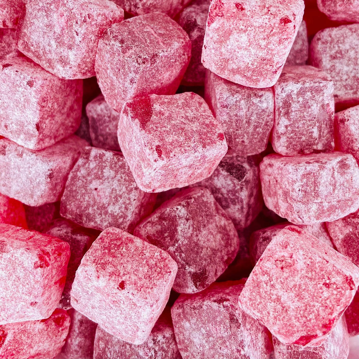 Cola Cubes Sweets with a dark red colour and dusted with sugar