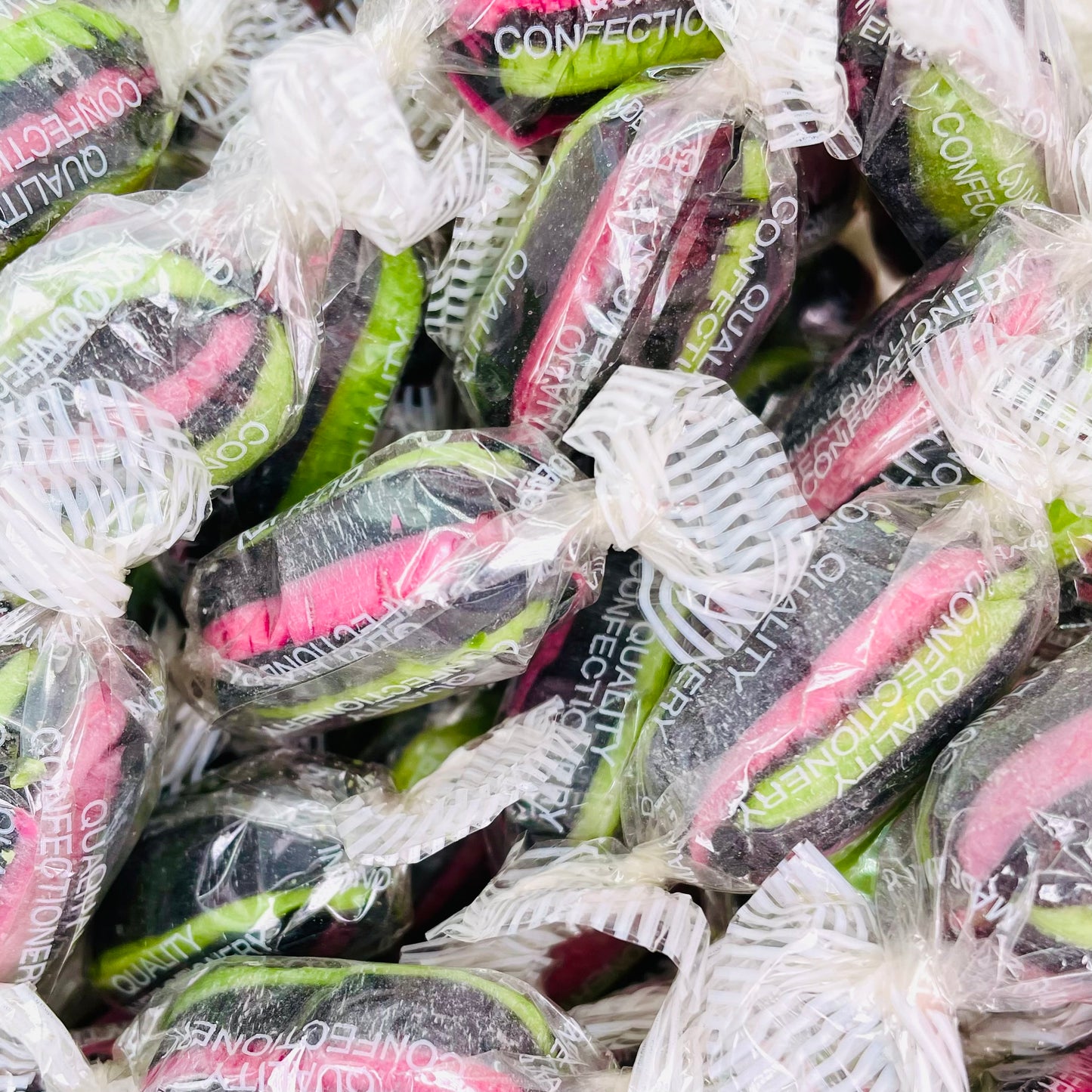 Individually wrapped liquorice and aniseed boiled sweets with pink, green and black stripes