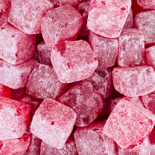 Cola Cubes Sweets with a dark red colour and dusted with sugar 