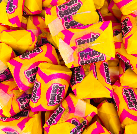Rectangular fruit salad sweets wrapped in a yellow and pink wrapper 